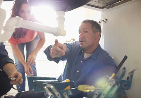 Plumbers Working on Pipes Under Sink | Phoenix Plumbing Services